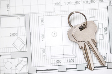 Silver house keys composition with architectural drawing