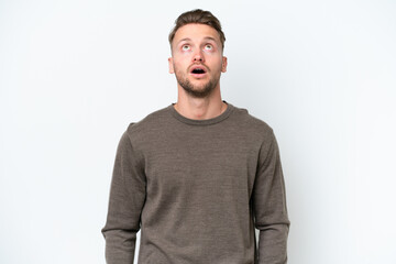 Young blonde caucasian man isolated on white background looking up and with surprised expression