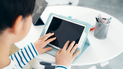 タブレットの画面をタッチする男の子