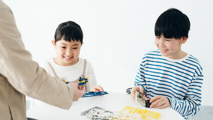 プラモデルを作る子どもたちと男性　電子工作