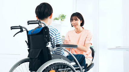 車椅子に乗った男の子を診察する看護師　医師