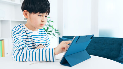 タブレットを見ながら勉強する男の子
