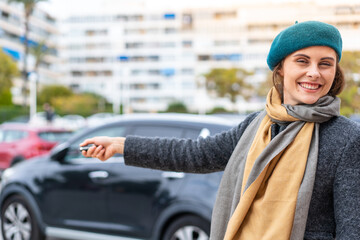 Brunette woman holding car keys at outdoors