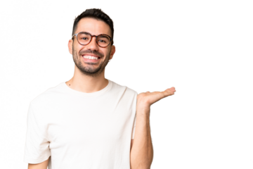 Young handsome caucasian man over isolated chroma key background holding copyspace imaginary on the palm to insert an ad