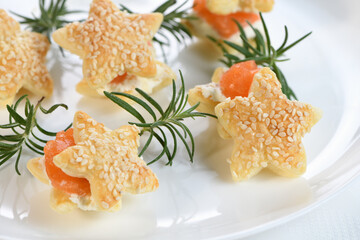 Festive appetizer of puff pastry in the shape of a star, stuffed with salmon and soft cheese. The perfect appetizer for your holiday table.