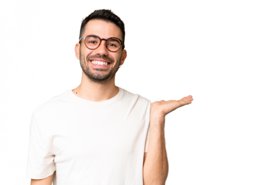 Young handsome caucasian man over isolated chroma key background holding copyspace imaginary on the palm to insert an ad