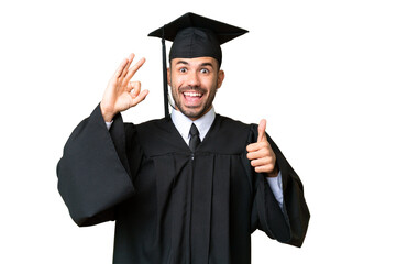 Young university graduate man over isolated chroma key background showing ok sign and thumb up...