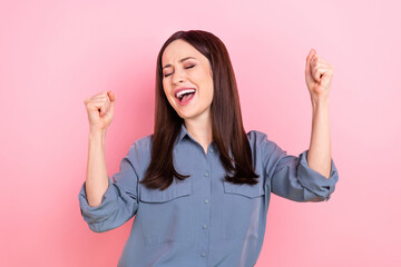 Photo of overjoyed successful business woman wear blue shirt raise fists up celebrate weekend...