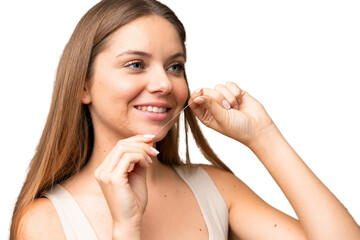 Young blonde woman over isolated chroma key background with dental floss. Close up portrait