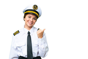 Airplane pilot woman over isolated chroma key background pointing to the side to present a product