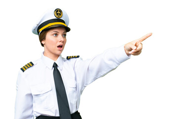 Airplane pilot woman over isolated chroma key background pointing away