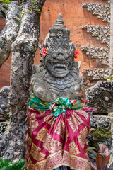 Classic Balinese stone sculpture with a colorful sarong