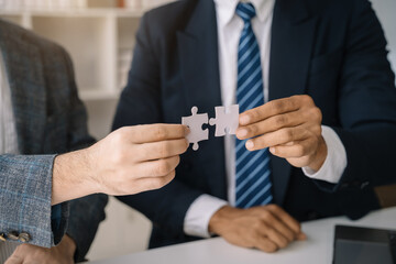 Business people asian with jigsaw puzzle pieces in office, Successful teamwork and partnership concept.