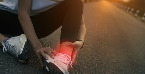 Ankle twist sprain accident in sport exercise running jogging.low key lighting.