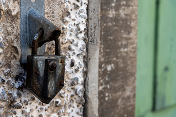 old metal lock atached on the wall of an old building
