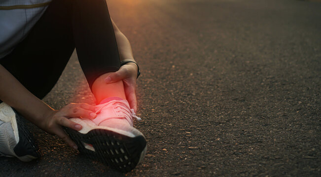 Ankle twist sprain accident in sport exercise running jogging.low key lighting.