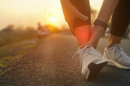 Ankle twist sprain accident in sport exercise running jogging.low key lighting.