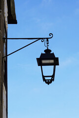 Fototapeta na wymiar Tradicional street lamp lantern hanging from the wall of a historic building 
