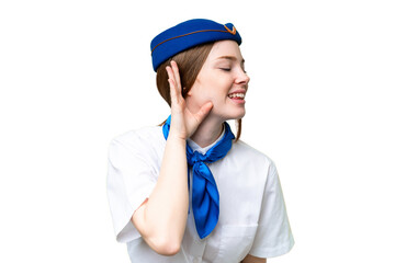 Airplane stewardess over isolated chroma key background listening to something by putting hand on the ear