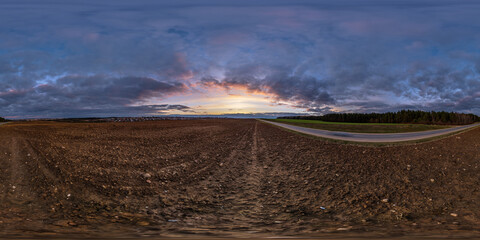 360 hdri panorama near asphalt road with evening clouds on evening sky in golden after before...