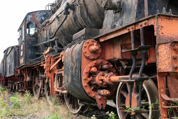 Fototapeta na wymiar Old steamed locomotive in a junkyard
