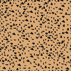 abstract seamless pattern of leopard skin. black irregular brush spots on a  gold background. Abstract print from the skin of wild animals. Simple irregular design.