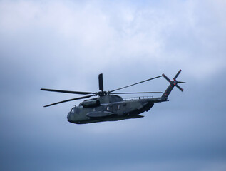 Fototapeta na wymiar Ein militärischer Hubschrauber mit offener Heckklappe am Himmel.