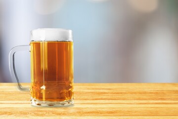 A glass of cold beer on table in bar background.