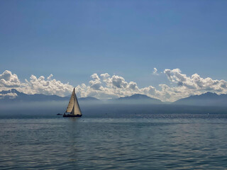 Sailing boat on the lake in front of a mountain backdrop