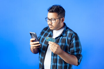 a shocked adult student reading text message on his mobile phone with wide eyes, isolated on single color background