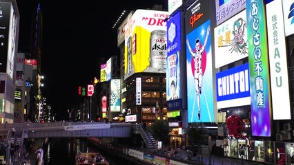 OSAKA, JAPAN : View of Dotonbori area. Tourist destinations, filled with neon signs, clubs and restaurants. Time lapse shot, sunset to night. Logo and signs are blurred or overwritten for this video.