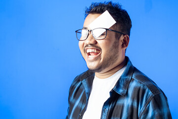 Obraz premium indian man wearing eye glasses showing empty card funny expression