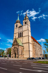 Fototapeta na wymiar Church of Saint Jochannis, Jochanniskirche, in front of highway street in historical downtown of Magdeburg at blue Spring sky