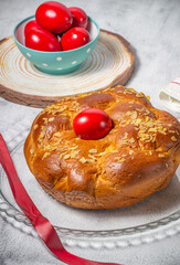 Easter traditional bread, greek tsoureki and red eggs on a table 
