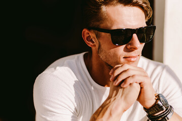 portrait of a brutal man in sunglasses and watch outdoors. Stylish man wearing casual. Men's beauty, fashion. Optics for men.
