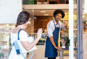 Owner greets customer in front of store.