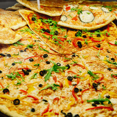 Sliced pizza on a thin crust.