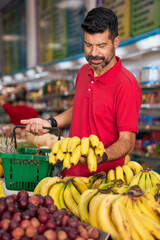Consumer chooses bunch of banana in a neighborhood store
