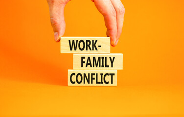 Work-family conflict symbol. Concept words Work-family conflict on wooden block on a beautiful orange table orange background. Businessman hand. Business work-family conflict concept. Copy space.