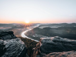 Fototapeta premium Beautiful shot from the edge of a cliff to a river during the sunset