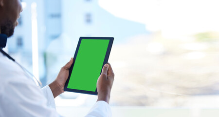 Doctor, man and hands with green screen on tablet for Telehealth, healthcare or life insurance at the hospital. Hand of male medical professional holding technology with mockup or copy space display