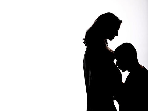 a pregnant couple on a white background with black shadows with space for advertising and text in isolation. The shadow of a pregnant couple. Girl and guy
