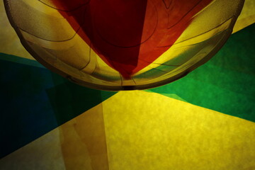 Borde semicircular de un bol de vidrio con papeles multicolores en formas geométricas de triángulos y formas rectas, forman un diseño abstracto muy original para los fondos