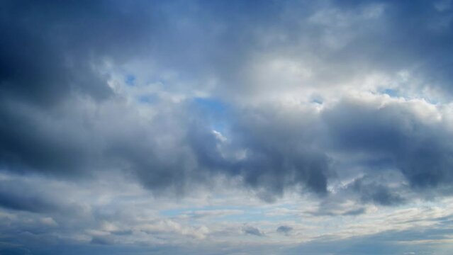 Dramatic sky with dark cumulus clouds, timelapse. Menacing heavy clouds in the blue sky, time lapse