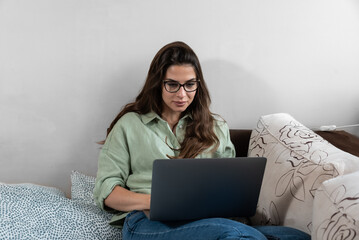 Young woman freelancer working on computer at home. Attractive businesswoman studying online, using laptop software, web surfing information or shopping in internet store. Internet job search concept