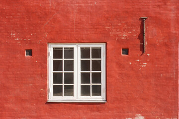 Fototapeta na wymiar Traditional red wall with window of a historic danish building at Kastellet in Copenhagen in Denmark