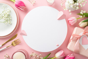 Fototapeta na wymiar Mother's day table setting concept. Top view flat lay of trendy plates, cutlery, tulips, gift box, and decorative hearts on pastel pink background with empty circle for text or advert