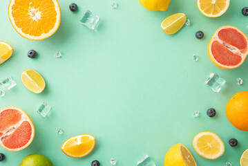 Citrus paradise concept. Top view of juicy oranges, lemons, limes and grapefruits on turquoise background with empty space for promotional text
