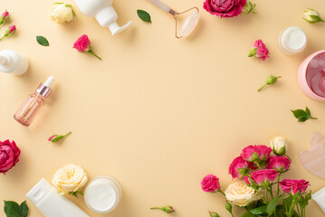 Relaxing self-care concept. Flat lay top view of face cream bottle, serum, and massage roller with delicate roses on a pastel beige background and an empty space for copyspace or advert