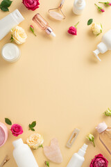 Radiant skin concept. Trendy top view vertical flat lay of cream bottle, serum, and facial roller with rose petals on a pastel beige background and an empty space for copyspace or branding